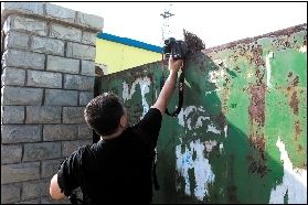 記者對(duì)廠內(nèi)情況進(jìn)行拍攝時(shí)，大門后伸出一把掃帚擋鏡。