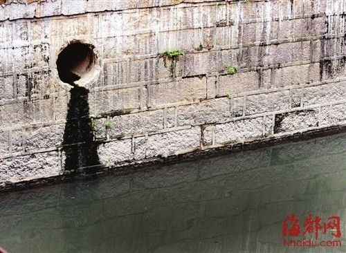 內(nèi)河一處排污口，正在流出墨黑色污水。